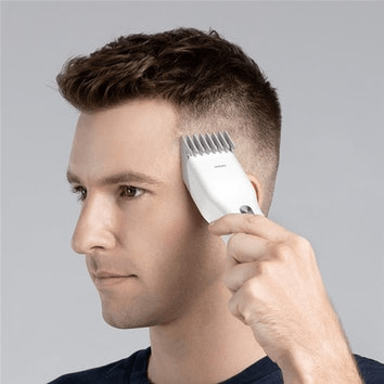 mężczyzna używający białego trymera do włosów